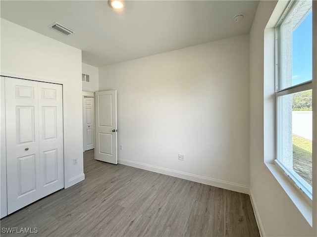 unfurnished bedroom with a closet and light hardwood / wood-style flooring