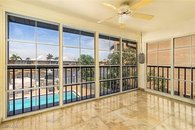 unfurnished sunroom featuring ceiling fan