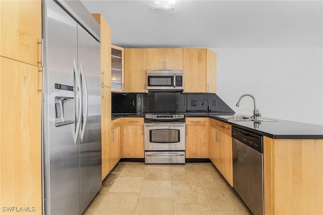 kitchen featuring appliances with stainless steel finishes, sink, decorative backsplash, kitchen peninsula, and light brown cabinets