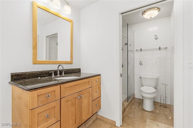 bathroom featuring tile walls, tile patterned flooring, vanity, walk in shower, and toilet