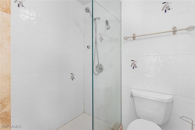 bathroom featuring toilet, tile walls, and a tile shower