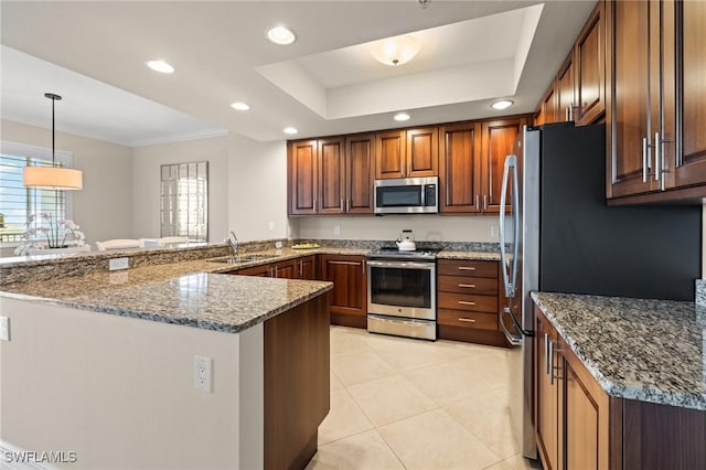 kitchen with stone countertops, decorative light fixtures, kitchen peninsula, a raised ceiling, and stainless steel appliances