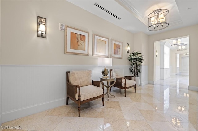 interior space featuring an inviting chandelier, crown molding, decorative columns, and a raised ceiling