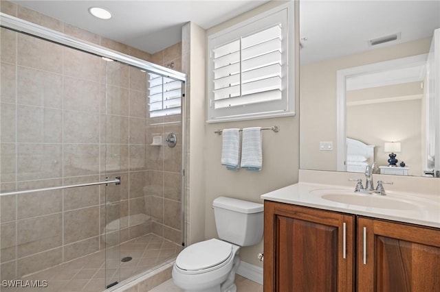 bathroom featuring vanity, a shower with shower door, and toilet