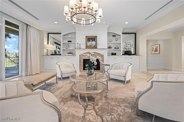 living room featuring built in shelves, crown molding, a tiled fireplace, and an inviting chandelier