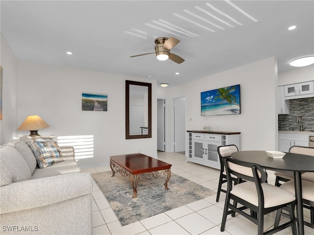 living room with light tile patterned flooring, ceiling fan, and sink