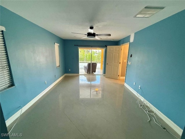 spare room with ceiling fan and light tile patterned flooring