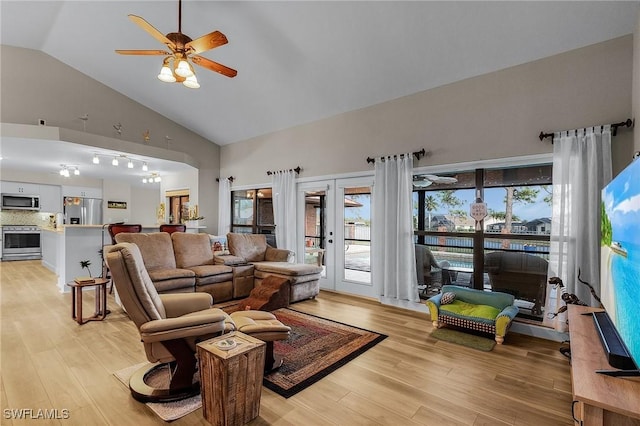 living room featuring ceiling fan, high vaulted ceiling, light hardwood / wood-style floors, and french doors