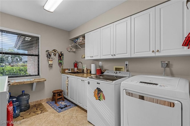 laundry area featuring washer and dryer, sink, cabinets, and light tile patterned flooring