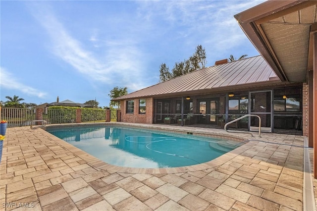 view of swimming pool featuring a patio and a sunroom