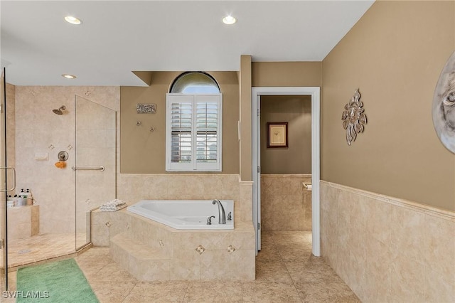 bathroom featuring tile patterned flooring, independent shower and bath, and tile walls