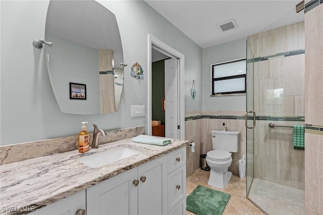 bathroom featuring walk in shower, toilet, tile walls, vanity, and tile patterned flooring