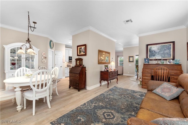 dining space with crown molding and light hardwood / wood-style floors