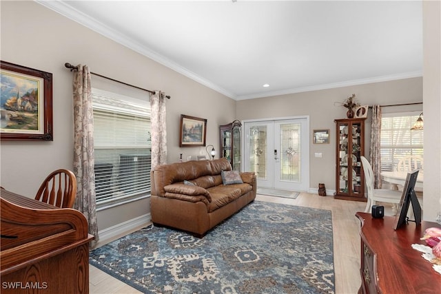 living room featuring ornamental molding, light hardwood / wood-style flooring, and french doors