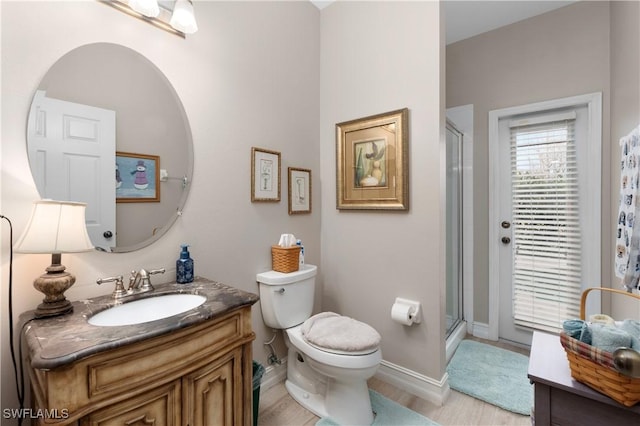 bathroom featuring vanity, hardwood / wood-style floors, an enclosed shower, and toilet