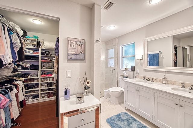 bathroom with vanity, toilet, and a tile shower