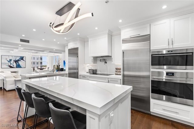 kitchen with a sink, white cabinetry, recessed lighting, stainless steel appliances, and dark wood-type flooring
