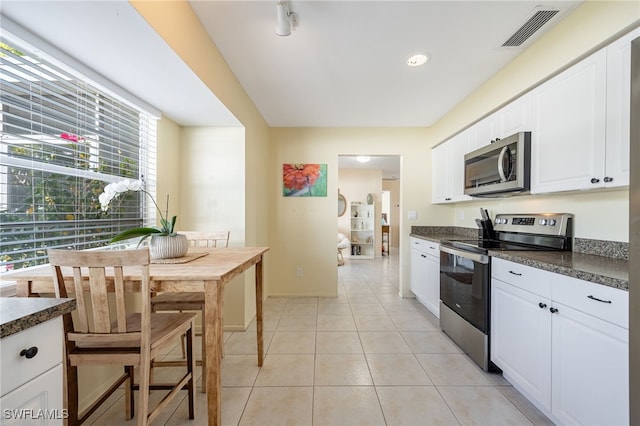 kitchen with white cabinetry, stainless steel appliances, and light tile patterned floors