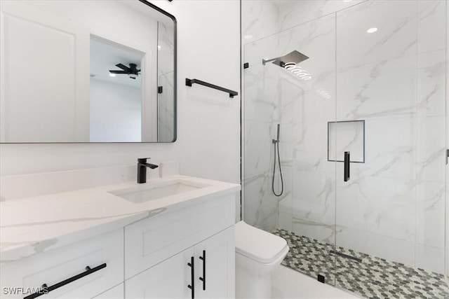 bathroom featuring vanity, a shower with shower door, and toilet