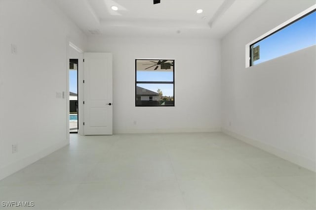 empty room with plenty of natural light and a tray ceiling