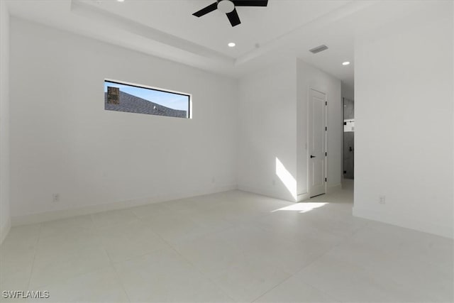 empty room with a raised ceiling and ceiling fan