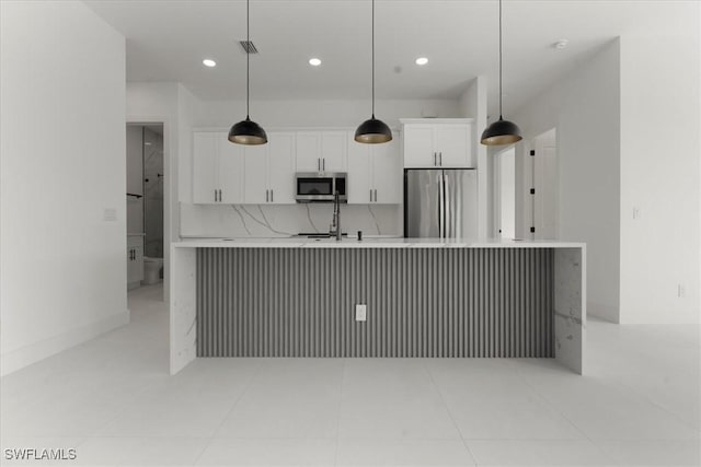 kitchen featuring sink, white cabinetry, tasteful backsplash, appliances with stainless steel finishes, and pendant lighting