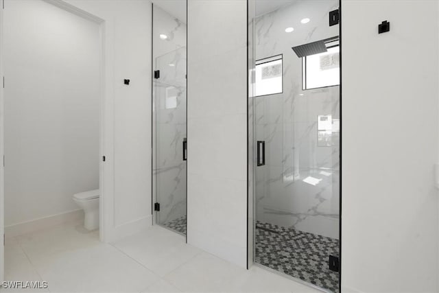 bathroom featuring toilet and a shower with shower door