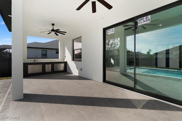 view of patio with a swimming pool, sink, and ceiling fan