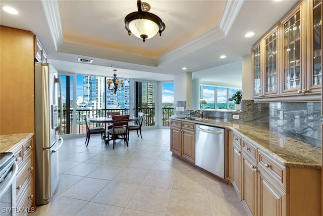 kitchen featuring hanging light fixtures, stainless steel appliances, light stone countertops, a raised ceiling, and crown molding