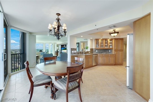 dining room featuring sink, light tile patterned flooring, floor to ceiling windows, and an inviting chandelier