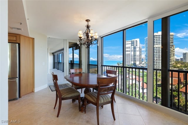 tiled dining space featuring a notable chandelier and expansive windows