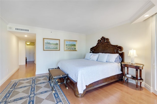 bedroom with wood-type flooring and crown molding