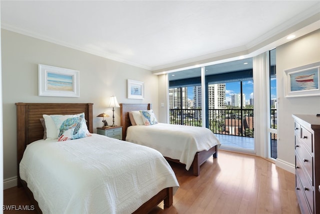 bedroom featuring light hardwood / wood-style floors, crown molding, expansive windows, and access to outside