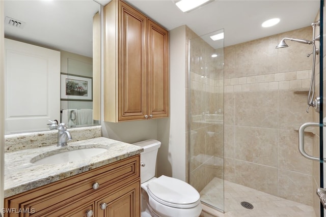 bathroom with toilet, an enclosed shower, and vanity