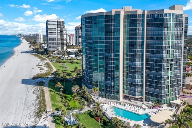 birds eye view of property featuring a water view and a beach view