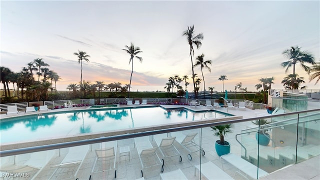 pool at dusk featuring a patio