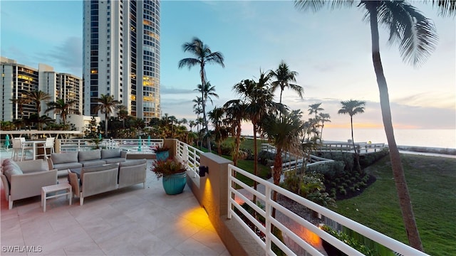 balcony at dusk with a water view and an outdoor hangout area