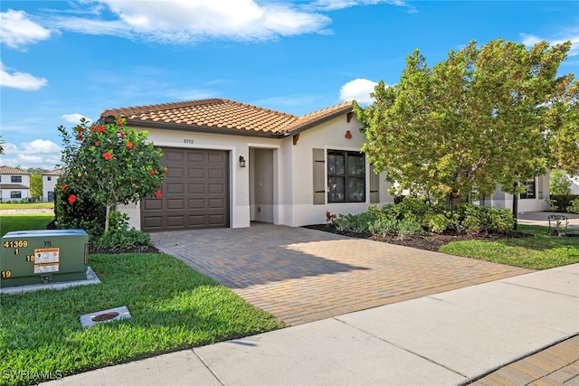 mediterranean / spanish-style house featuring a garage and a front lawn