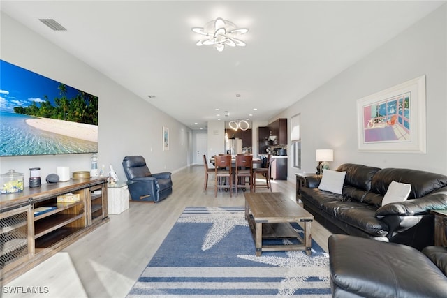 living area with recessed lighting, light wood finished floors, visible vents, and baseboards