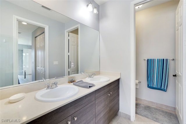 full bath with tile patterned flooring, double vanity, visible vents, and a sink