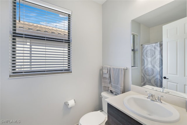 full bath with toilet, a shower with shower curtain, and vanity