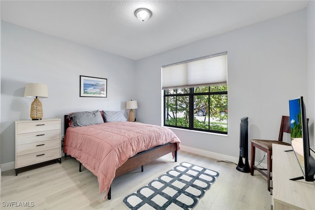 bedroom featuring baseboards and light wood-type flooring