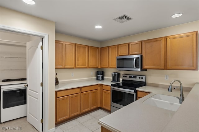 kitchen featuring stainless steel appliances, light tile patterned flooring, and sink