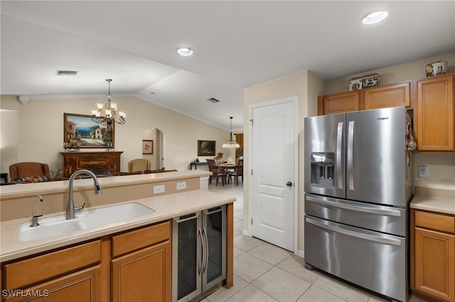 kitchen featuring lofted ceiling, sink, pendant lighting, stainless steel fridge, and light tile patterned floors