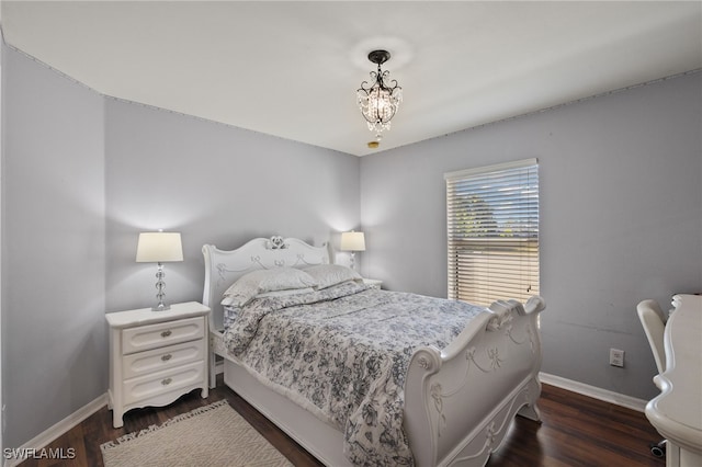 bedroom featuring dark wood-type flooring and a notable chandelier