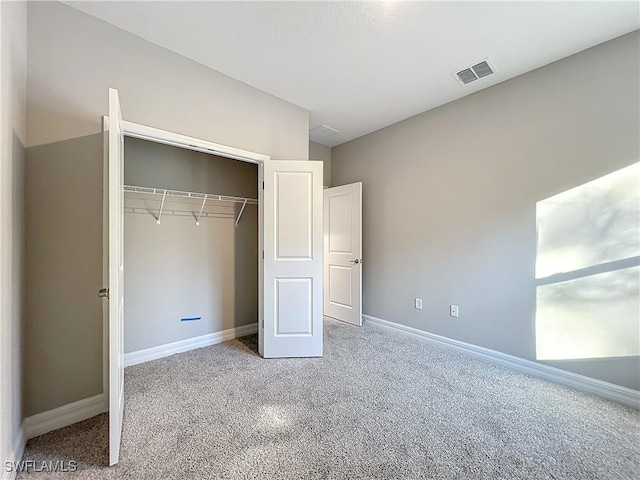 unfurnished bedroom featuring a closet, vaulted ceiling, and carpet