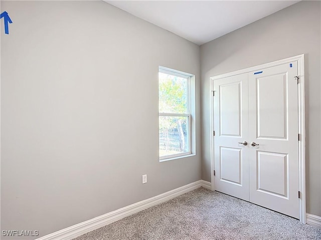 unfurnished bedroom with light carpet and a closet