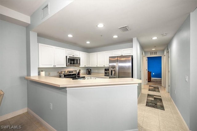 kitchen featuring white cabinetry, appliances with stainless steel finishes, kitchen peninsula, and light tile patterned floors