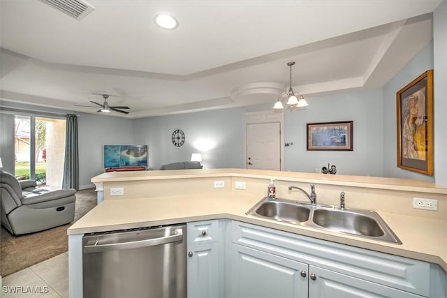 kitchen with sink, dishwasher, a tray ceiling, light tile patterned flooring, and ceiling fan with notable chandelier