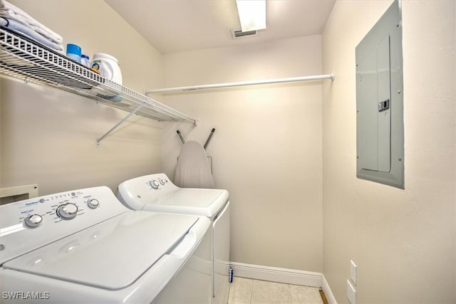 clothes washing area with light tile patterned floors, electric panel, and washer and dryer